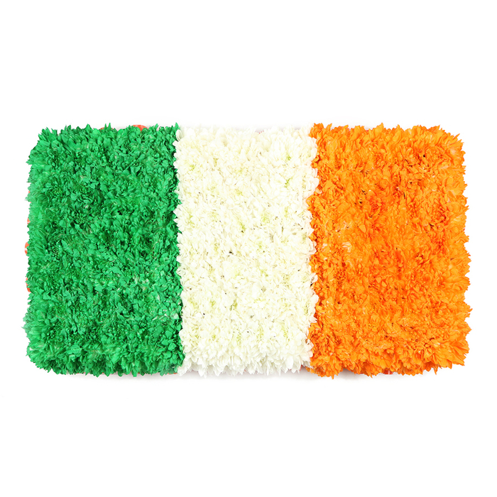 In a bright studio near Brent Cross, a rectangular floral banner reproduces the Irish tricolor with quiet dignity. The left green stripe is a textured field of tiny green blossoms, the white center glows softly with tightly packed white petals, and the right orange band radiates warmth through countless small blooms. The petal surfaces create a tactile, sculpted effect that invites careful observation from every angle. The flag is arranged with three equal vertical panels, the scale and spacing precise yet touched by the organic irregularity of living flowers. The blend of colours carries centuries of symbolism-the green for Irish nationalism and Catholic tradition, the white for peace, the orange for the Protestant community-woven into a contemporary craft piece. Set against a clean white backdrop, the work reads as a celebration of culture and unity, ideal for features on St Patrick's Day, Ireland's national identity, or community remembrance. Local viewers from Hendon to Golders Green will recognise the hand of a skilled neighborhood florist, attentive to detail, scent, and light. The bouquet is available for delivery across Brent Cross and the surrounding NW London wards, offering a respectful, tangible expression of heritage that can be shared during celebrations or moments of memory.