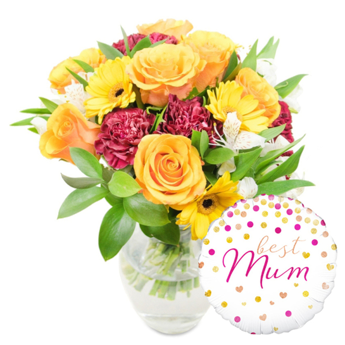A vivid, thoughtfully composed gift sits against a pure white background: a generous bouquet placed slightly centre-left in a clear glass vase, paired with a round white foil balloon at the lower right. The flowers read warm and celebratory - fully opened roses in rich orange and bright yellow create a luminous core, their velvety petals layered in gentle spirals. Interspersed are bright yellow gerbera daisies with dark centres that pop like mini suns, and deep burgundy carnations whose ruffled, plush petals provide a luxurious, grounding contrast. Sprays of delicate white alstroemeria, marked with faint freckles, add a refined lightness that lifts the palette. Lush green foliage - glossy broad leaves and slender twiggy stems - fills and frames the arrangement, and the clear vase allows a view of the trimmed stems and clear water, underscoring the freshness of the collection. The glossy balloon is festooned with scattered gold and fuchsia confetti dots and tiny heart motifs; across its face the flowing fuchsia script reads best Mum, giving the whole gift an intimate, celebratory voice.

The photograph's soft, even lighting accentuates petal texture and glass reflections with no harsh shadows, and you can almost imagine the gentle scent of roses and greenery. Expertly balanced and hand-finished, this bouquet makes an ideal Mother's Day or birthday surprise for someone special. Brent Cross Flowers arranges similar combinations for same-day delivery across Brent Cross, Hendon and Golders Green, often chosen by customers shopping at the nearby Brent Cross shopping centre or travelling along the North Circular.