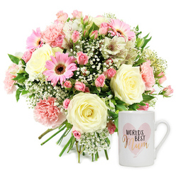 Set against a crisp white background that highlights every subtle colour and texture, this image captures a heartfelt floral gift set perfect for honouring a mum in Brent Cross. To the left, a lush, dome-shaped bouquet is tightly hand-tied, with the cut stems forming a neat, visible bundle at the base, giving it a freshly crafted, artisan feel. Creamy roses sit proudly at the centre, their spiralling petals soft and full, suggesting comfort and enduring love. Around them, blush-pink carnations with finely ruffled edges ripple gently outward, while vivid pink gerbera daisies with rich dark brown centres beam towards the viewer, bringing a touch of bold cheer as bright as the shopfronts around Brent Cross Shopping Centre. Dotted between the larger blooms, petite pink spray roses add intimacy, some blossoms fully open, others still nestled in bud, hinting at stories yet to unfold. Airy clusters of white gypsophila weave through the arrangement like tiny clouds, softening the transitions between flowers and giving the bouquet a dreamy, romantic halo. White alstroemeria stems, each petal brushed with subtle reddish-brown streaks, arc gracefully among the other blooms, their slender forms adding elegance and a sense of movement. Sprigs of fresh green foliage peek out, providing contrast and reinforcing the freshly picked, garden-inspired mood. To the right of the bouquet, a smooth white ceramic mug stands upright, its handle turned slightly outwards in an inviting gesture. The mug features a blush watercolor-style heart, and within it the phrase WORLD'S BEST Mum appears, with WORLD'S BEST in neat black capital letters and Mum in gleaming metallic gold script that looks as though it would shimmer under kitchen lights on a quiet Brent Cross morning. The combination of the sentimental mug and soft pastel bouquet conveys warmth, gratitude, and affection, perfect for Mother's Day surprises or birthday deliveries across the NW11 and NW4 neighbourhoods.