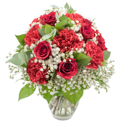 A classic red and white bouquet stands in a simple, clear glass vase against a pristine white backdrop, its design refined yet heartfelt, much like a thoughtful gift sent to a flat near Brent Cross Shopping Centre. The dominant feature is the deep red roses, their petals wrapped in tight, velvety spirals that hint at blossoming romance and enduring affection. Clusters of crimson carnations surround and support the roses, their many ruffled petals catching light and shadow, adding generous volume and a soft, cloud-like texture to the arrangement. Between these bold red blooms, fine stems of white baby's breath weave delicately, each tiny blossom like a fleck of snow, brightening the composition and creating a gentle, airy contrast. Threads of greenery anchor the bouquet, from dark, glossy rose leaves to rounded eucalyptus leaves in a muted, silvery green, introducing subtle movement and a natural freshness reminiscent of greenery around Brent Cross and up towards Golders Green. The bouquet is shaped into a full, rounded dome, with no gaps or awkward spaces, reflecting experienced floristry and careful attention to balance. The transparent vase, with its modestly flared rim and stable base, holds the evenly trimmed stems in clear water, allowing you to see the clean, straight lines that support the blooms above. Bright, even lighting falls across the arrangement, intensifying the reds and crisp whites while giving the greens a healthy, dewy look. The overall mood is one of warm celebration and sincere emotion, suitable for romantic gestures, heartfelt thank-yous, or simply bringing an elegant, uplifting touch to a dining table near Hendon Way or a cosy home off the North Circular.