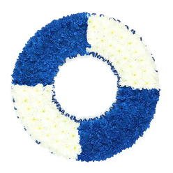 A striking circular floral tribute is carefully arranged to resemble a traditional life ring, photographed against a bright white background so that its bold colours and shapes stand out in calm, clear contrast. The wreath itself is entirely composed of small, closely nestled flowers, likely chrysanthemums, which form a smooth, cushion-like surface across the entire ring. Divided into four equal sections, the ring alternates between a deep, royal blue and a crisp, pure white, creating a strong nautical look you might associate more with riverside scenes than the busy streets around Brent Cross Shopping Centre. The top left and lower right quadrants glow with an inky blue intensity, each tiny petal contributing to a richly layered field of colour that feels contemplative and steady. Opposite them, the top right and lower left sections are made up of immaculate white blooms that catch the light, bringing an air of tranquillity, remembrance, and release. The transitions between the coloured blocks are neat and precise, giving a sense of careful craftsmanship and intention. Encircling the inner edge of the wreath is a narrow band of dark blue ribbon, gently ruffled, which frames the hollow centre and subtly echoes the ropes or edging of a real lifebuoy while never taking attention away from the flowers. The open centre of the ring is clearly visible, reinforcing the symbol of protection, a guiding presence, and the idea of being held safely through life's rougher waters. This design works beautifully as a funeral wreath or condolence tribute for someone with maritime ties or a reputation as a lifesaver in their family, and it is the sort of thoughtful piece that Brent Cross Flowers might prepare for delivery to local chapels or crematoria.