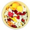 A top-down view captures a round, light cream-yellow ceramic bowl entirely carpeted with a generous mix of fresh flower petals, evoking both abundance and quiet solace. Inside, the larger petals belong to roses in a palette that moves from deep, velvety crimson and burgundy to bright sunflower yellow and soft apricot peach. They are loosely layered and gently cradled by the bowl, each petal's curved edge folding into the next to create a soft, rippling surface. Interwoven among these warm, saturated tones are countless tiny white florets, akin to hydrangea, whose finely frilled petals lend an airy delicacy and a sense of light drifting through the arrangement. The petals appear freshly gathered, as if a florist in Brent Cross has just finished preparing them for a memorial service and paused a moment to appreciate their quiet beauty. Light falls evenly from above, drawing subtle highlights along the smooth rose surfaces and sinking into the creases to form gentle shadows that add depth. The contrast in textures is palpable: thick, cool rose petals that feel almost like silk, set against the fragile, tissue-thin white blossoms. Together, they create a visual language of affection, remembrance, and peace. This bowl of petals could easily be part of a funeral tribute in Brent Cross, ready to be scattered over a coffin, placed around a condolence book, or shared among family members as a final, symbolic gesture of farewell. The scene invites stillness, reflection, and the comforting presence of nature during times of loss.