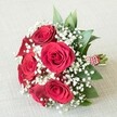 Tucked elegantly onto a cream-hued linen evocative of Brent Cross's relaxed contemporary style, this bouquet features approximately six full-bloomed red roses whose deep, velvety petals spiral outward in a lush display of timeless romance. Nestled among them, baby's breath scatters its tiny, snowy-white flowers, softening the arrangement and providing a gentle contrast that evokes the first light on Brent Reservoir. Sprigs of glossy green foliage complete the look, bringing vibrancy and structure-each leaf carefully chosen for its health and sheen. The sturdy stems are bound with a vivid red and white striped ribbon, adorned with a delicate trail of white pearls, highlighting the bouquet's classic yet modern flair. Bathed in soft, even light, each petal, leaf, and pearl strand gleams with clarity. Perfect for a Brent Cross bridesmaid procession, surprise anniversary, or an intimate romantic gesture, this arrangement embodies warmth, expertise, and the enduring traditions of Brent Cross Flowers. Its presence brings not only the beauty of flowers but also a touch of community spirit to any occasion in North London.