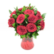 A lavish bouquet of deep red roses fills a translucent red glass vase, set sharply against a pure white studio background so that every detail stands out. Around a dozen to fifteen roses are gathered in a classic, rounded shape, each bloom fully open yet still holding its graceful form, with velvety petals spiralling tightly from the centre and softening at the edges. The red is a rich, ruby-crimson, glowing as though it has been polished, and the smooth surfaces of the petals catch subtle highlights that suggest gentle, diffused light rather than harsh glare. Between the roses, an abundance of dark, glossy green foliage, likely ruscus, emerges in small sprays, its pointed leaves shining with a waxy sheen and providing a cool, verdant contrast to the warmth of the flowers. The vase itself curves gently from a narrower base to a flared rim, its ribbed or lightly undulating surface refracting the light and deepening the red tone where glass overlaps. Through the tinted glass, the faint silhouettes of stems can be seen, anchoring the arrangement and giving it a grounded, natural presence. The composition feels romantic and deliberate, the kind of bouquet a Brent Cross florist might prepare for a heartfelt anniversary surprise or a Valentine's Day delivery to one of the nearby residential streets off the North Circular. The overall impression is one of timeless passion and sincerity, a modern yet classic rose design that radiates love, intimacy, and quiet celebration, ideal for someone wanting to send a bold, unmistakable message of affection in the Brent Cross area.
