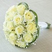 A classic yet contemporary bridal bouquet, masterfully arranged by a local florist near Brent Cross Shopping Centre. The focus rests on a clustering of creamy, pale yellow roses-ten to twelve blooms whose petals are fresh, full, and just beginning to open into perfect rosettes. Interspersed among the roses is a generous burst of baby's breath, whose tiny, soft white flowers create a dreamy, airy texture that envelopes the bouquet like morning mist near Brent Reservoir. A few sophisticated loops of deep green foliage frame the arrangement, adding dynamic contrast and visual interest reminiscent of Brent Cross's green corners. The flowers' stems are gathered and finished with an immaculate white satin ribbon, forming a polished, classic handle for easy carrying at celebrations or ceremonies. Set against a subtle, cream linen background, the bouquet's serene colours and textures draw immediate attention, conjuring images of joyful unions, heartfelt anniversaries, and special milestones celebrated throughout the Brent Cross area. The overall effect is elegant, hopeful, and designed to bring a sense of gentle festivity to any local event.