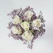 A breath of calm elegance infuses this hand-tied bouquet, artfully composed by Brent Cross's expert florists. Six immaculate white roses unfurl their petals in precise, circular layers, each bloom glowing with a gentle sheen and kissed at the base with the faintest green-echoing the freshness of spring mornings in the heart of Brent Cross. Encircling these blooms is a plume of pale lavender and lilac statice, the tiny blossoms bunched in airy tufts that soften the arrangement and add depth, reminiscent of light mist rolling across Brent Reservoir. The bouquet sits atop a smooth, off-white tabletop, its clean backdrop casting the flowers into serene focus under a wash of even, soft light. Every detail comes alive: the roses' velvet touch, the statice's feathery texture, the subtle interplay of crisp white and cool purple. The design radiates a sense of unity, hope, and intimate celebration-perfect for brightening a neighbour's day, honouring a new beginning, or providing a gentle gesture in times of sympathy. Available for same-day delivery from Brent Cross Flowers, this bouquet embodies the thoughtful artistry, local warmth, and understated sophistication prized by those throughout the NW4 community.