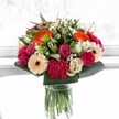 A bouquet that feels like a vibrant pop of joy-an explosion of colour and life, handcrafted by a Brent Cross florist who understands the rhythms of this spirited community. Dazzling orange gerberas radiate warmth, perfectly complemented by peach and blush roses, and the sumptuous velvet of magenta carnations. Creamy ivory roses lend softness and serenity, balanced by the gentle cheerfulness of peachy gerberas. Framed with crisp, glossy greens reminiscent of Hendon Park's leafy expanses, the bouquet displays harmony in every detail, each bloom carefully lit by bright, airy daylight that makes the colours almost dance. The composition's energy is both welcoming and poised, suitable for commemorating birthdays, anniversaries, or infusing everyday moments with Brent Cross freshness. Every flower, every texture, reflects not only expert craftsmanship but also a deep love for community-an arrangement bursting with happiness and the thoughtful artistry that makes each Brent Cross occasion memorable.