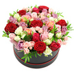 A beautifully crafted rose hat box rests against a pure white background, its elegance immediately drawing the eye. The container is a classic, round black box, encircled at the base by a slender line of red ribbon that gives a polished, couture finish reminiscent of chic boutiques near Brent Cross. Above it, a generous dome of roses overflows with colour, each bloom nestled snugly beside the next, forming a continuous landscape of petals. The bouquet is rich with deep red roses that convey passion and depth, softened by clouds of blush pink and creamy white flowers. Spikes of vivid fuchsia and warm coral roses add a joyous, celebratory note, while gentle peach tones create a soft transition between the stronger colours. Interspersed throughout, lavender and mauve roses contribute a refined, modern touch, echoing the style of contemporary homes around Brent Cross Shopping Centre. Texturally, the arrangement is fascinating: some roses are open wide, revealing layered, velvety petals, while others are only beginning to unfurl, including dainty spray rose clusters that bring fine detail. Bright green leaves peek through the blooms at intervals, providing crisp contrast and enhancing the impression of fresh, just-arrived quality from a local florist. The even, soft lighting in the image emphasises the rounded shape of the dome and the subtle variations in tone across each petal. This hat box arrangement feels perfect for intimate anniversaries, special birthdays, or thoughtful congratulations, ready to become a striking centrepiece on a dining table or coffee table anywhere across Brent Cross, Hendon, or nearby Cricklewood.