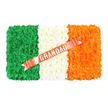 A symbolic Irish flag floral tribute is shown laid out neatly on a plain white background, the colours and textures carefully balanced to convey both pride and tenderness. The design is a crisp rectangle segmented into three vertical panels. The left panel is a dense expanse of rich green blossoms, probably chrysanthemums or similar button flowers, pressed closely together to create a velvety surface. The central panel is filled with clean white blooms, their small, rounded heads forming a soft and tranquil strip. On the right, a vivid orange panel shines brightly, echoing the shape and density of the other sections while adding a gentle sense of warmth. A coral-red satin ribbon runs diagonally across the centre, crossing from the lower left over the white and orange bands toward the upper right, its sheen catching subtle highlights. Emblazoned across this ribbon in silver block capitals is the word GRANDAD, the letters bold yet respectful, making the dedication clear. Discreet white pins secure the ribbon into the white floral section, showing the care taken in its placement. This tribute would be especially poignant at a funeral or memorial in Brent Cross or surrounding North London areas, where families with Irish heritage gather to honour a beloved grandfather. The piece feels both formal and deeply human, a floral expression of gratitude, shared memories, and cultural roots, crafted so that every petal, colour and line contributes to a final gesture of love and remembrance.