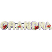 The scene presents a graceful funeral floral arrangement where the word GRANDMA is spelled out in large, individual block letters, resting neatly on a dark green support frame and photographed against a bright white background that highlights every detail. Each letter is composed of tightly packed white cushion chrysanthemums, their delicate, rounded petals forming a thick, velvety carpet that feels soft and gentle to the eye, a fitting symbol of tenderness and care. Just visible along the outer edges, a fine border of pale lilac or soft purple ribbon traces the outline of the letters, introducing a muted pastel tone that adds depth and a sense of quiet elegance without overpowering the calm white base. Carefully placed red accents bring warmth and emotion into the design. On the G, a cluster of deep red roses sits alongside a distinctive red-and-white calla lily, its patterned petals giving a unique focal point. The first A is marked with a single, heart-shaped red anthurium at its foot, its glossy finish standing out against the fluffy chrysanthemums. At the centre, the M is embellished with another grouping of luxurious red roses and a matching red anthurium, and the final A is topped with one last anthurium, echoing the earlier touches of red. The whole tribute feels balanced, dignified, and thoughtfully composed, exactly the sort of personalised GRANDMA lettering that families around Brent Cross shopping centre or along the North Circular might choose to place atop a coffin or beside the altar, expressing lasting love and honour for a much-loved grandmother.