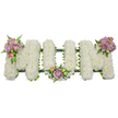A solemn, three-dimensional funeral tribute carefully formed to spell the word MOM in bold capital letters, each letter built from a cloud of small, snow-white chrysanthemums that give the surface a soft, pillowy texture. The composition sits against a pristine white backdrop so the cool, luminous whites read clearly, while the densely packed petals catch a soft, diffused light and suggest quiet purity and remembrance. At the upper left curve of the first M a tasteful cluster of pale lavender and blush-pink roses-some fully open, some tight buds-has been nestled among glossy green leaves and fine fern fronds; a smaller matching spray rests at the base of the central O, and a final mirrored cluster adorns the upper right arm of the closing M. These lilac and pastel pink roses introduce a whisper of warmth and the faint, velvety scent of roses that softens the stark white. A dark green structural outline-either a ribbon-wrapped frame or moss-covered base-peeks beneath the blooms, giving each letter a defined edge and reassuring stability while remaining discreet. The greenery, from delicate ferns to slender foliage, adds depth and a natural contrast that frames the white chrysanthemums with calm dignity. This bespoke sympathy arrangement conveys an intimate, personal farewell-a design often chosen for funerals, memorial services, or graveside dedications to honour a mother's memory. Imagined in the quiet mornings around Brent Cross and nearby Hendon, the piece reads as a gentle, carefully crafted expression of love and solemn respect, created with the precision and tenderness of an experienced funeral florist.
