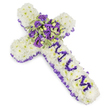 A tender, cross-shaped funeral tribute crafted from a dense cloud of pristine white chrysanthemums, each floret placed tightly to form a pillowy, reverent surface that reads of purity and calm. The cross sits against a clean white background in the photograph, the soft shadows highlighting the rounded texture of the chrysanthemum heads and the immaculate stitching of the design. Around the entire perimeter a ruffled purple satin ribbon-deep lilac to amethyst in tone-has been woven with gentle, even pleats, giving the piece a framed dignity and a subtle sheen that catches the light like twilight. Down the vertical arm the name MUM is lovingly spelt in rich purple blooms-small lisianthus or spray chrysanthemums-each letter mounted with careful spacing so the sentiment sits clearly against the white field. At the crossing of the arms a lush, compact spray forms the visual heart: velvety deep violet roses, paler lavender lisianthus, and small variegated green leaves with cream-edged margins, their surfaces mottled and lively. Tiny green berries and delicate filler stems tuck into the cluster, adding contrast and a natural, textural lift. The colours move from snowy white through a spectrum of purples-pale lavender, mauve, to almost-black violet-evoking purity, mourning and quiet honour. There is a faint, cool scent of fresh chrysanthemums and rose petal musk suggested by the composition, the kind of floral hush suited to a chapel or graveside. As a local Brent Cross floral design, this cross carries the simplicity and care families expect when commemorating a loved one, ready to be placed at a service in nearby Parish churches or memorial gardens around Cricklewood and Childs Hill.