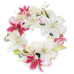 Resting on a spotless white background, this serene and elegant floral wreath reflects the quiet beauty Brent Cross is known for. The arrangement is densely woven into a perfect circle, with large, radiant white lilies drawing focus-their trumpet forms and soft stamens symbolising purity, peace, and thoughtful remembrance. Intermarried throughout are striking fuchsia pink lilies, their deep magenta tones and subtle dots infusing the piece with vibrance and heartfelt emotion. Arranged alongside are gentle clusters of blush pink and creamy white roses, in various stages of openness, creating a layered, romantic effect and lending a gentle, soothing fragrance reminiscent of a spring day near Clitterhouse Playing Fields. Delicate green foliage and sprigs of eucalyptus peek from behind the blooms, providing subtle structure and a whisper of natural freshness. The wreath's seamless, open circle conveys continuity and lasting tribute, making it perfectly suited for memorial services, funeral tributes, or expressions of condolence within Brent Cross and its neighbouring communities. Each element is carefully arranged by local florists to ensure a balanced, respectful atmosphere-providing families with a way to honour, remember, and comfort during times of loss, and available for discreet, same-day delivery throughout the area.