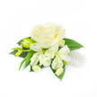Set against a pure, brilliant white backdrop, this delicate corsage reads like a small study in bridal purity and quiet celebration. The eye is drawn first to a single, fully opened creamy white rose at the centre - its velvety petals tightly furled at the heart and then unfurling outward in layered, pillowy curves that catch soft, diffused light and cast gentle shadows that suggest depth and volume. Flanking the rose are two alstroemeria-like blooms, their elongated ivory petals opening with an almost painterly softness, while to the left two narrow green buds remain closed, promising a later, tender unfurling. Tucked beneath and around the main flowers are tiny white daisy-style blossoms with pale yellow centres, adding an intimate, cottage-garden detail that softens the formal shape. A base of rich, dark green foliage - broad, smooth leaves with a satiny sheen - anchors the composition and provides a lush contrast to the whites. On the right-hand side a small cluster of lustrous white pearls nestles discreetly among the blooms, their cool sheen suggesting bridal jewellery and lending a classic, refined accent to the arrangement. There is an implied weight and texture here: the rose feels velvety and cool to the touch, the alstroemeria papery and delicate, the pearls smooth and hard. This corsage reads as a thoughtful piece for weddings, proms, or formal gatherings around Brent Cross - appropriate for a bride's wrist, a mother's corsage, or a guest's refined accessory when attending nearby venues such as Hendon Park or the community halls near the shopping centre.
